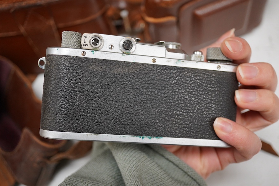 A Leica Model II camera in its original leather case, No. 204618, together with four additional cameras; a Zeiss Ikonta, a Zeiss Nettar, a Prinzflex 500E, and an Ensign Midget camera in its original card box with instruc